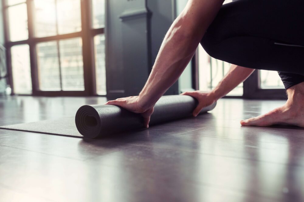 man in recovery folding a yoga mat