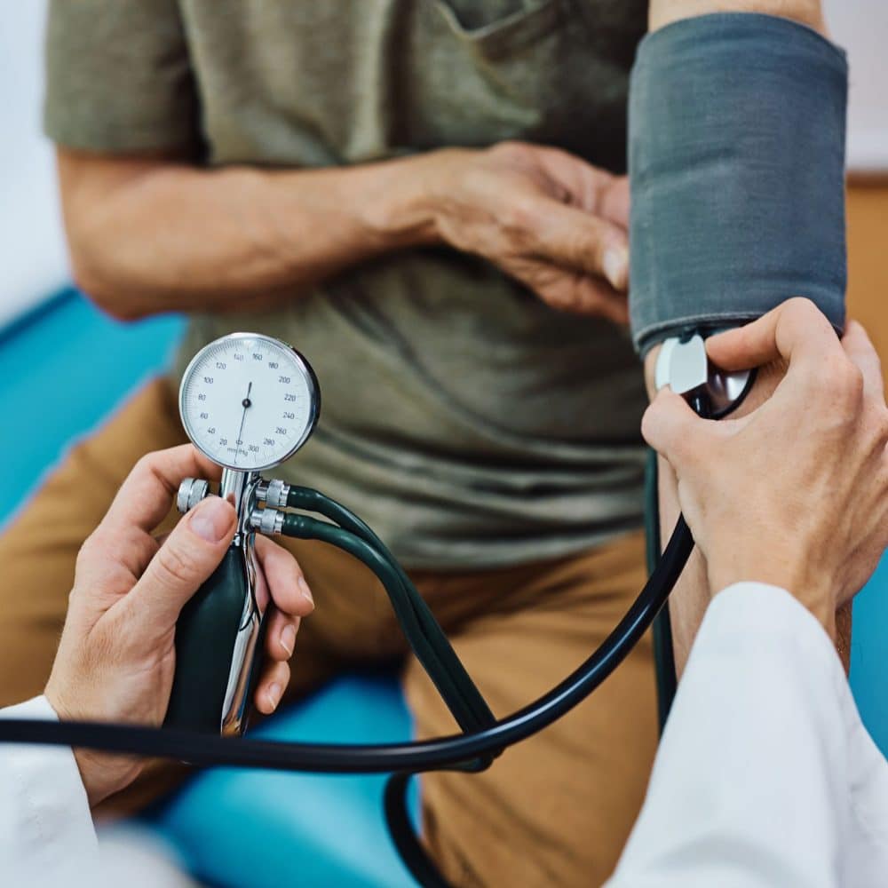 Close up of senior man getting his blood pressure checked during medical examination in the hospital.