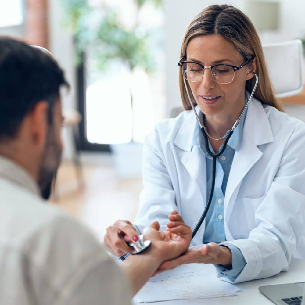 female doctor talking while explaining medical treatment while prescribing medication to patient in the consultation.